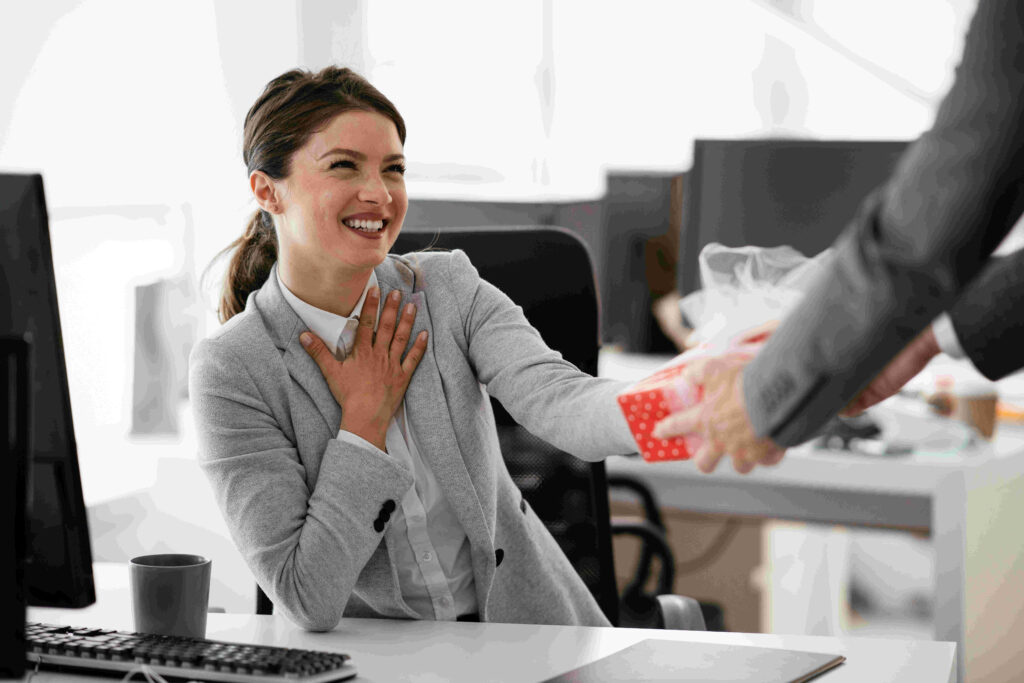 A happy female employee receiving a gift from her boss